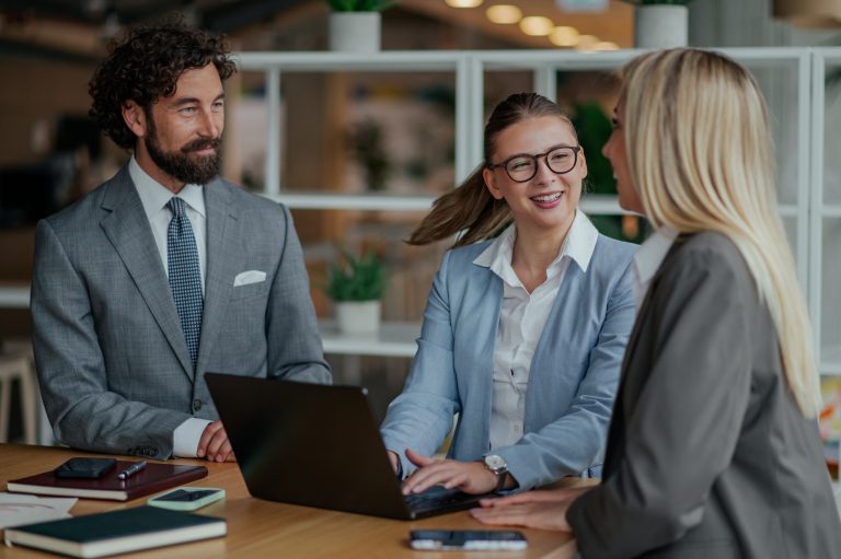 Business team working together on laptop in modern office