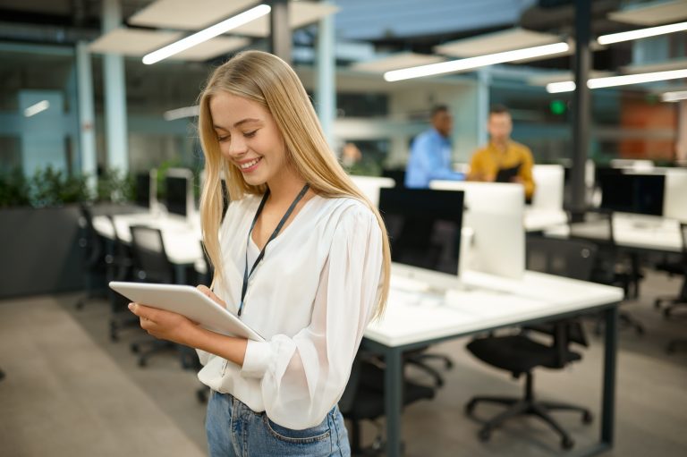 Smiling female manager holds laptop, IT office