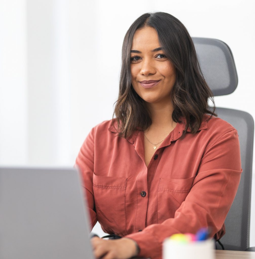 Young businesswoman working on laptop in bright office